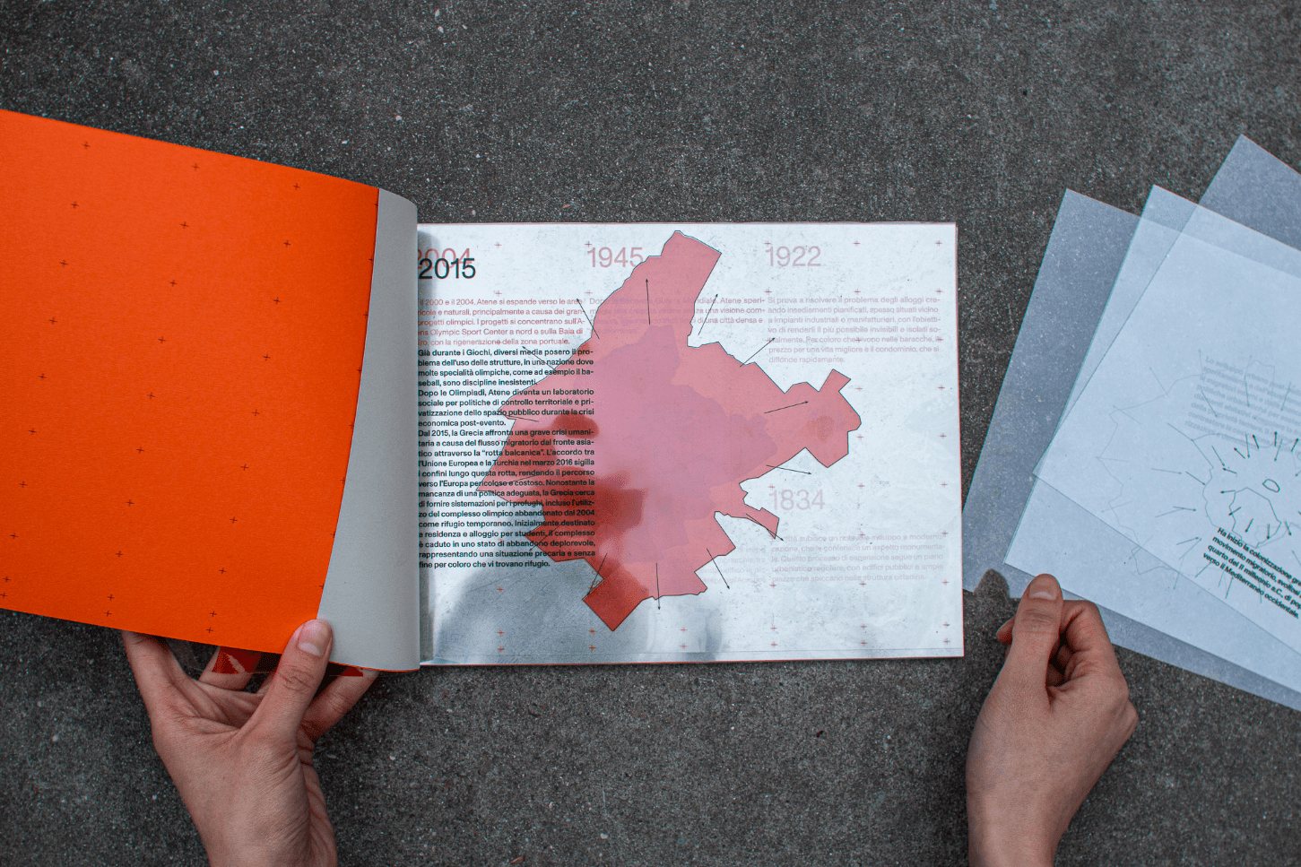 Open spread of the Anti-Atene book showing the use of acetate overlay in the project