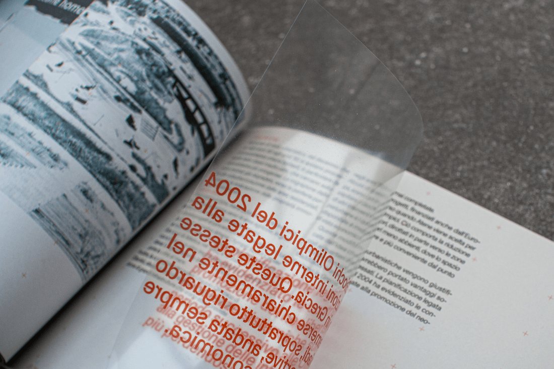 Open Anti-Atene book spread with a transparent acetate overlay on the right page